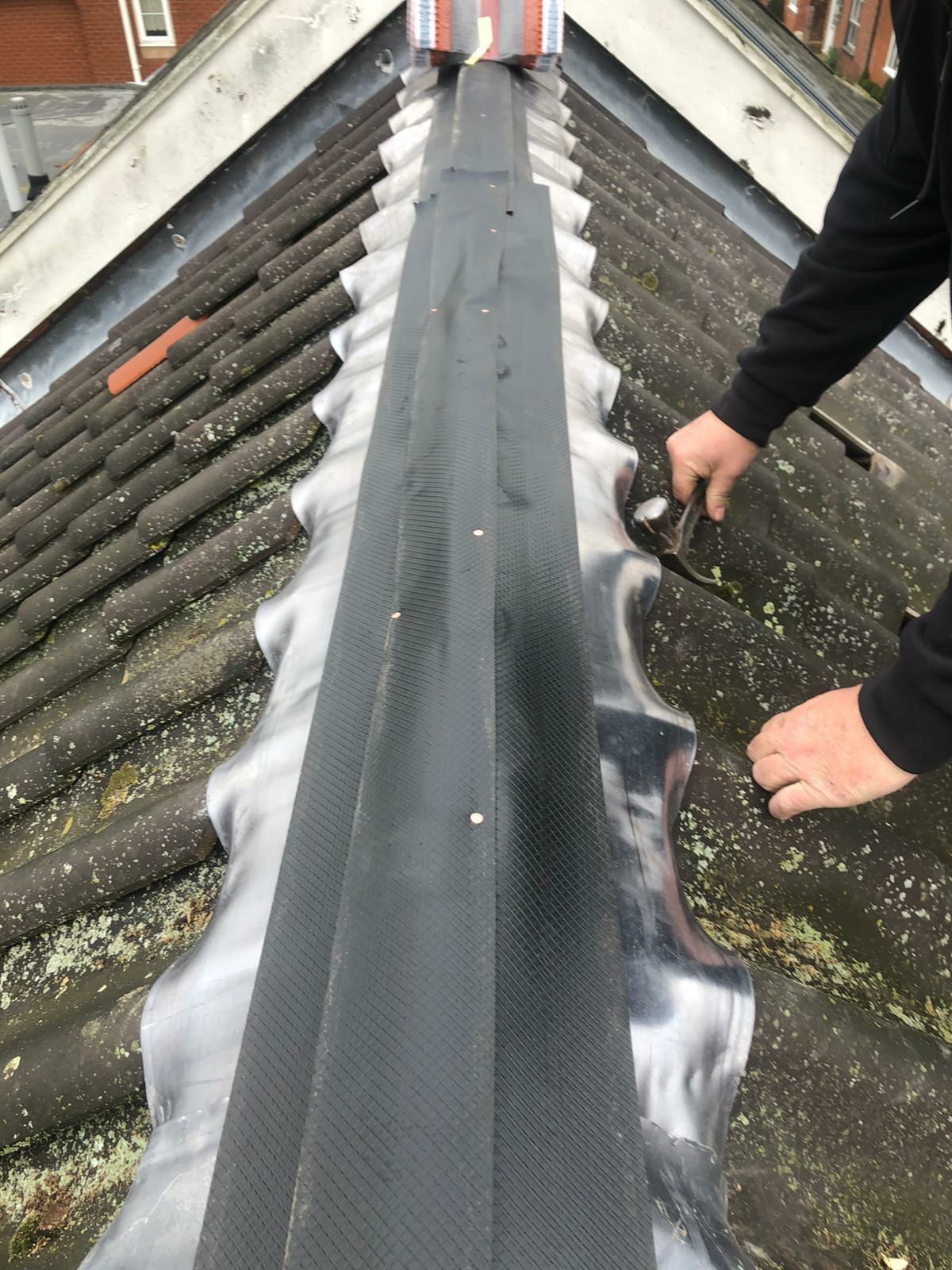 Fitting a new flashing strip along a tiled roof